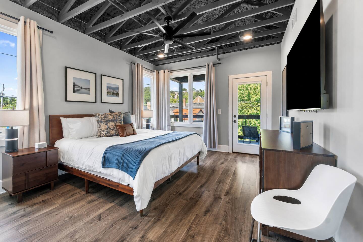 The spacious king bedroom includes a Smart TV, dedicated workspace, and balcony access.