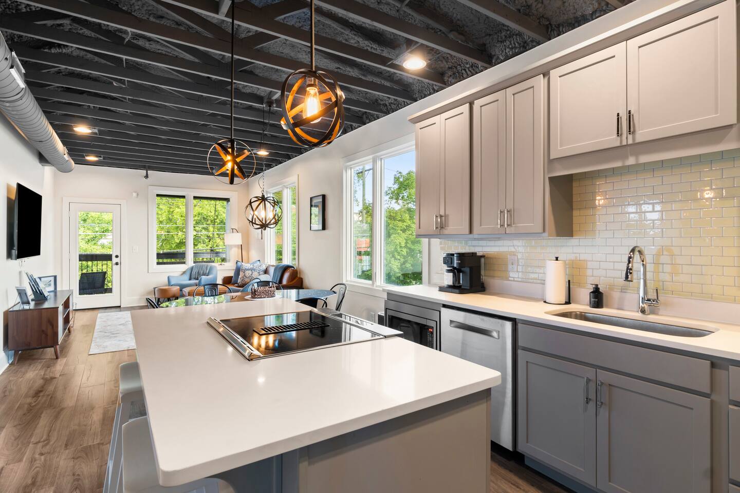 Bright modern kitchen with large island, open living space, and natural light