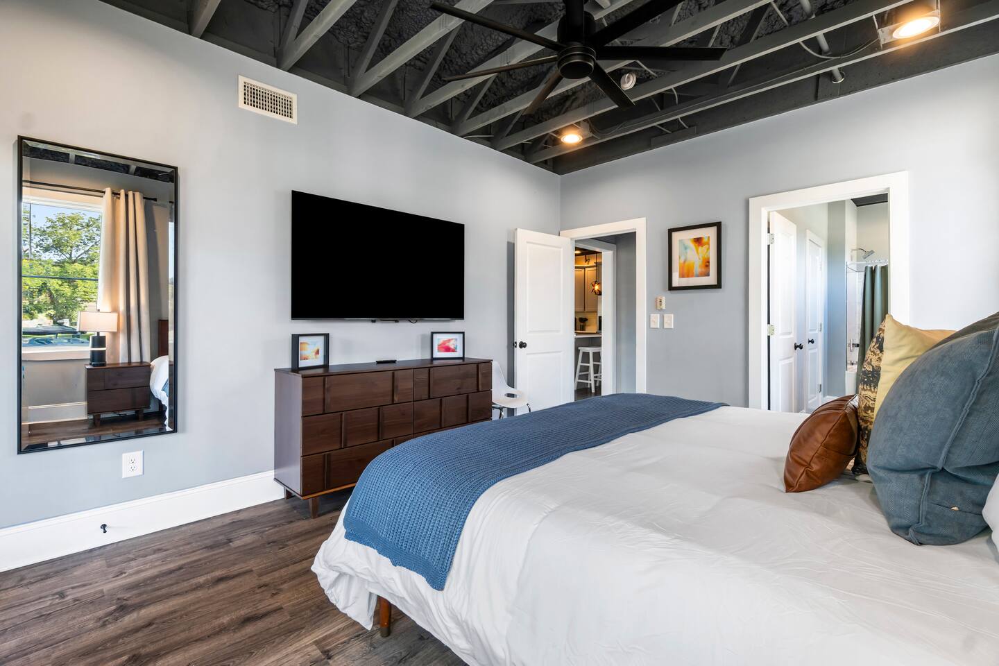 Bright modern bedroom with balcony access and stylish industrial ceiling