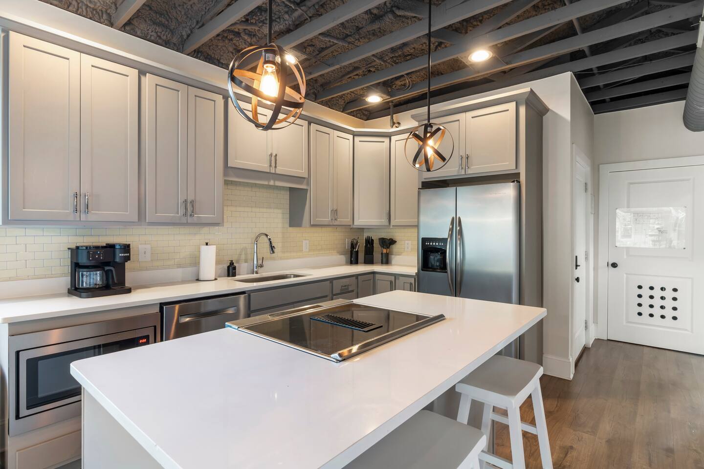 Bright modern kitchen with stainless appliances and stylish lighting