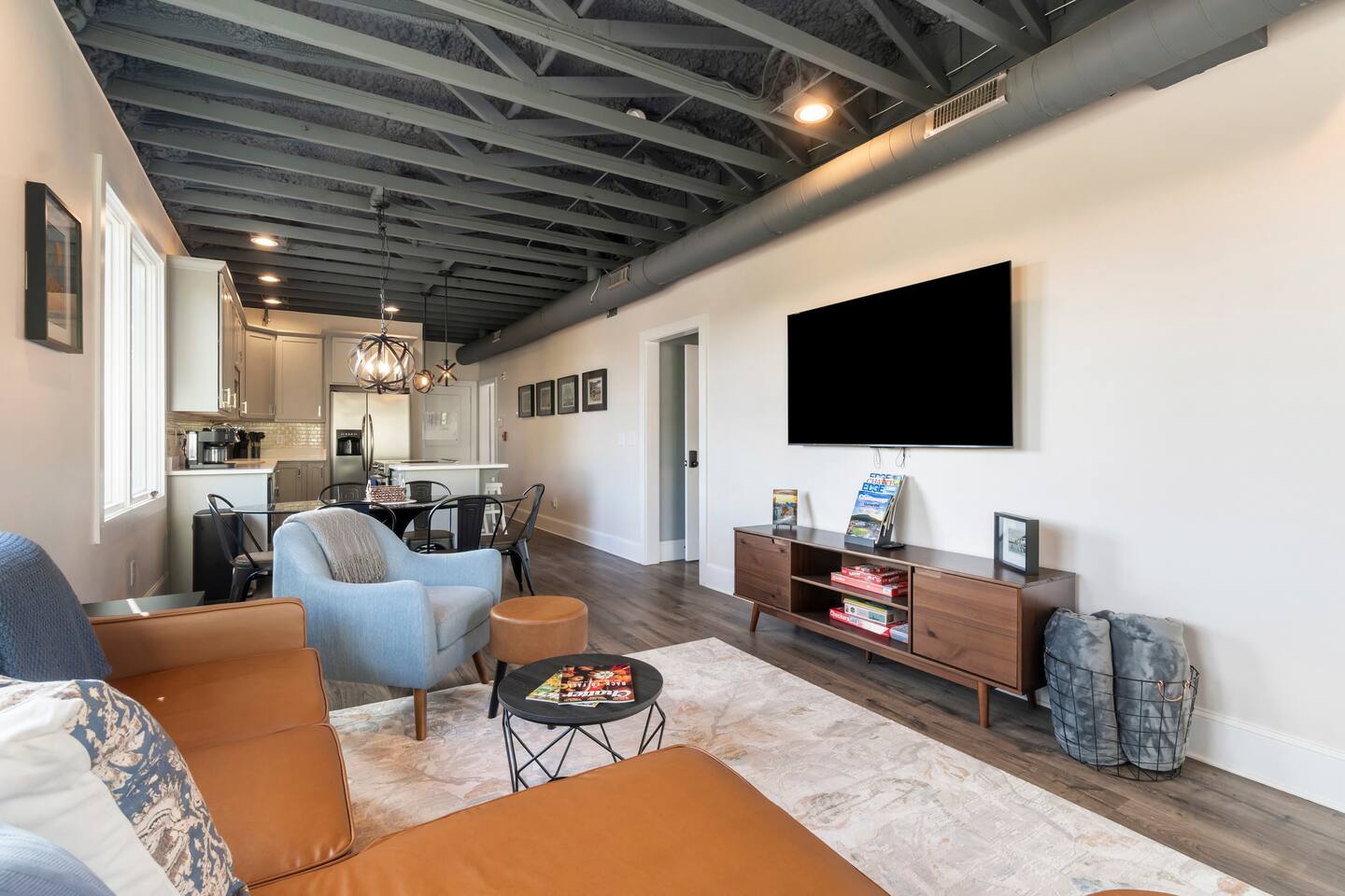 Bright modern lounge with large windows, stylish seating, and leafy views