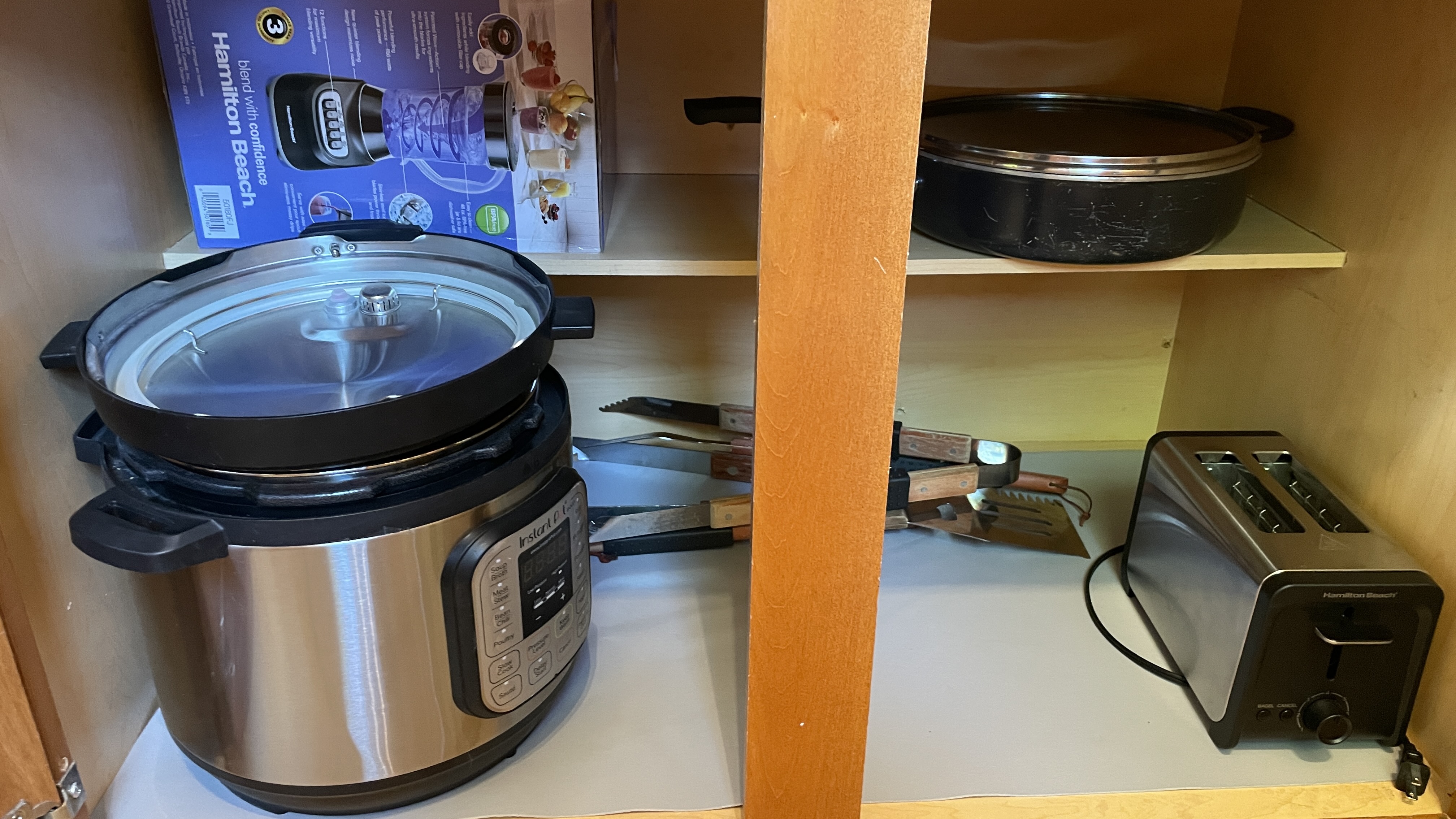 Well-equipped kitchen cabinet with appliances, cookware, and meal prep essentials