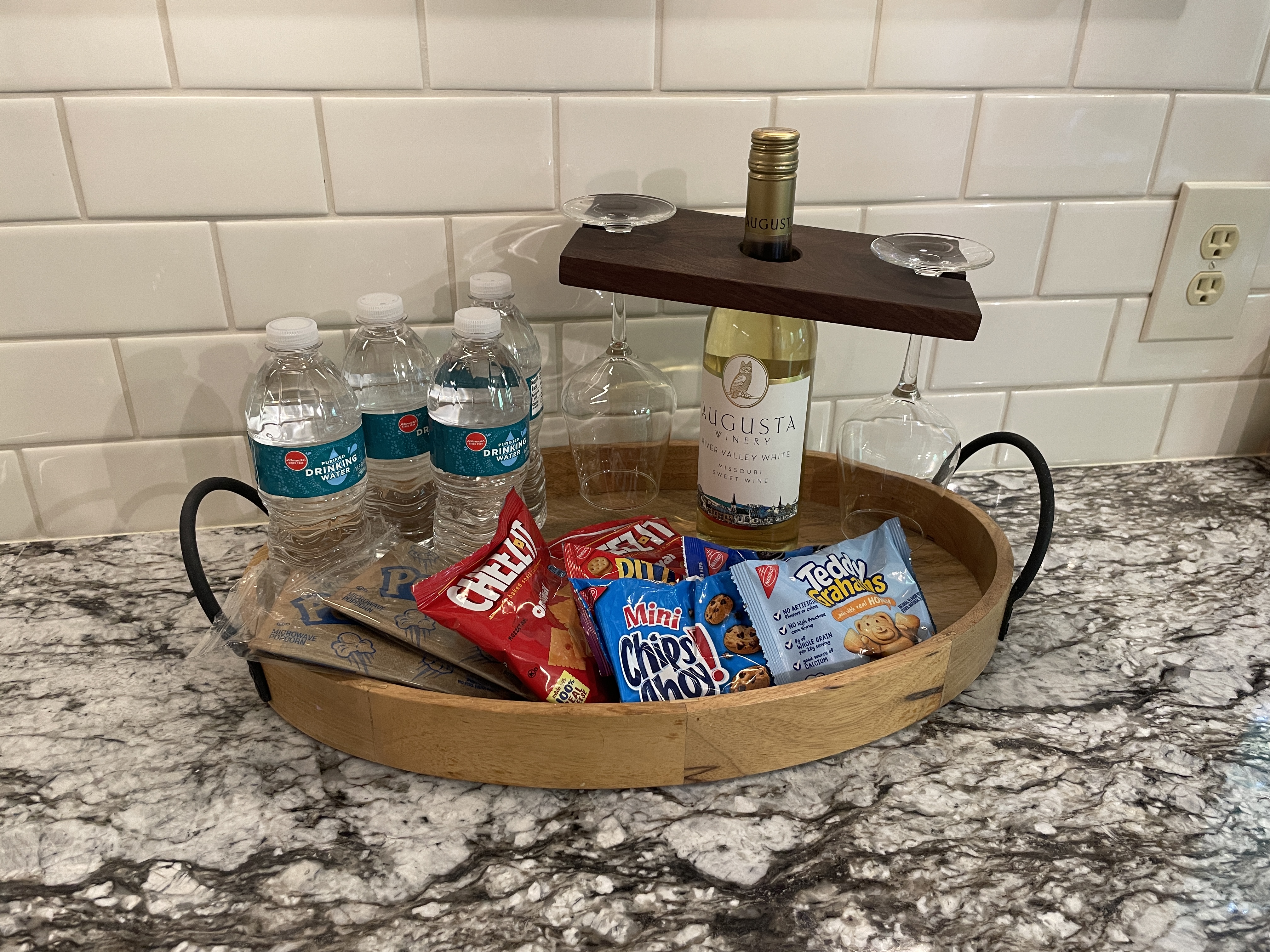 Thoughtful welcome tray with wine, snacks, and bottled water