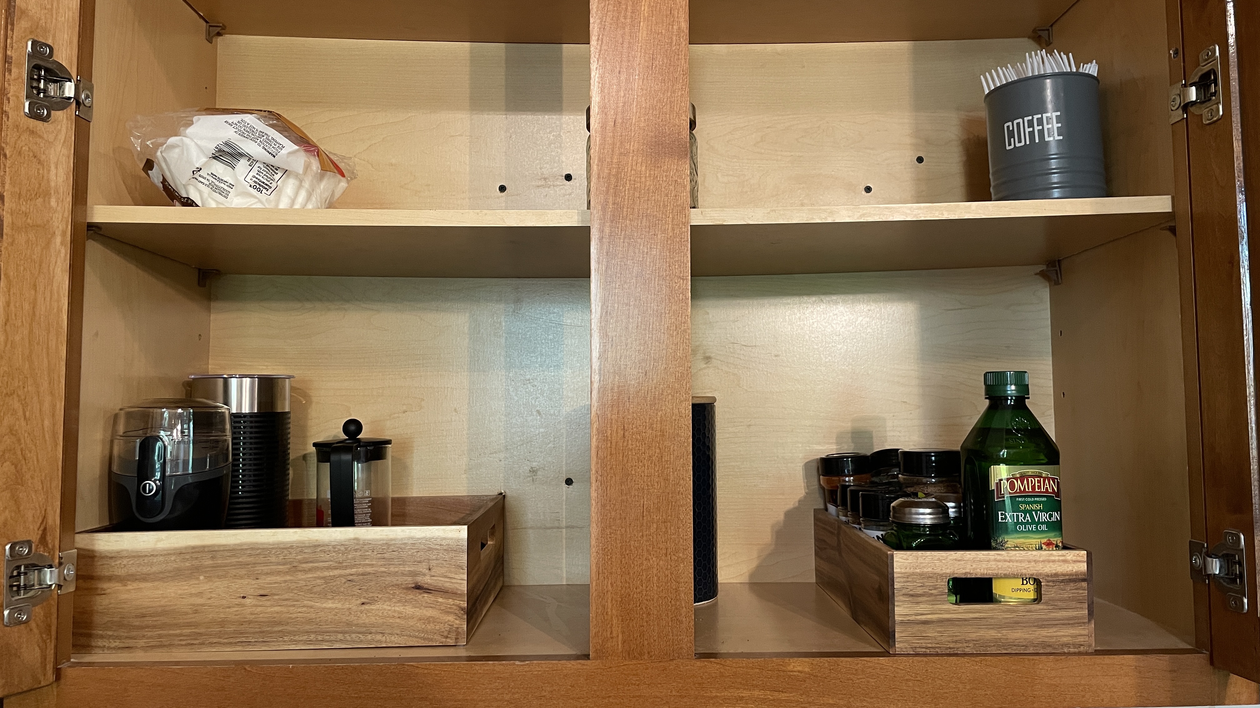 Organized kitchen cabinet with coffee station and cooking essentials