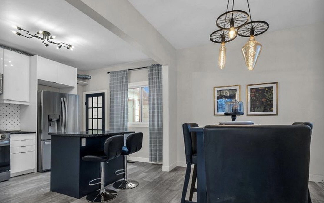Modern open kitchen and dining space with island seating and stylish lighting