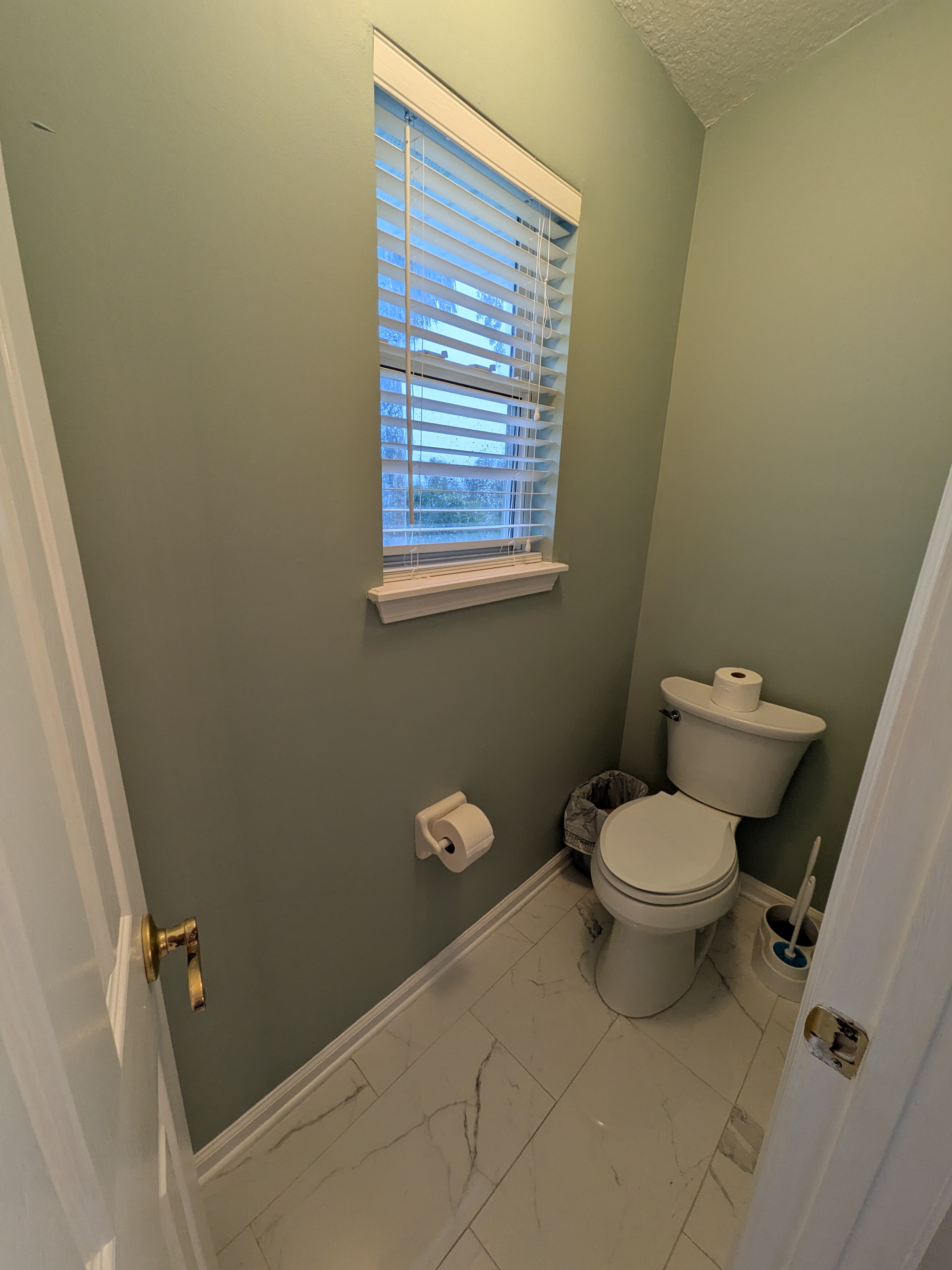 Bright half bath with natural light and clean, updated finishes