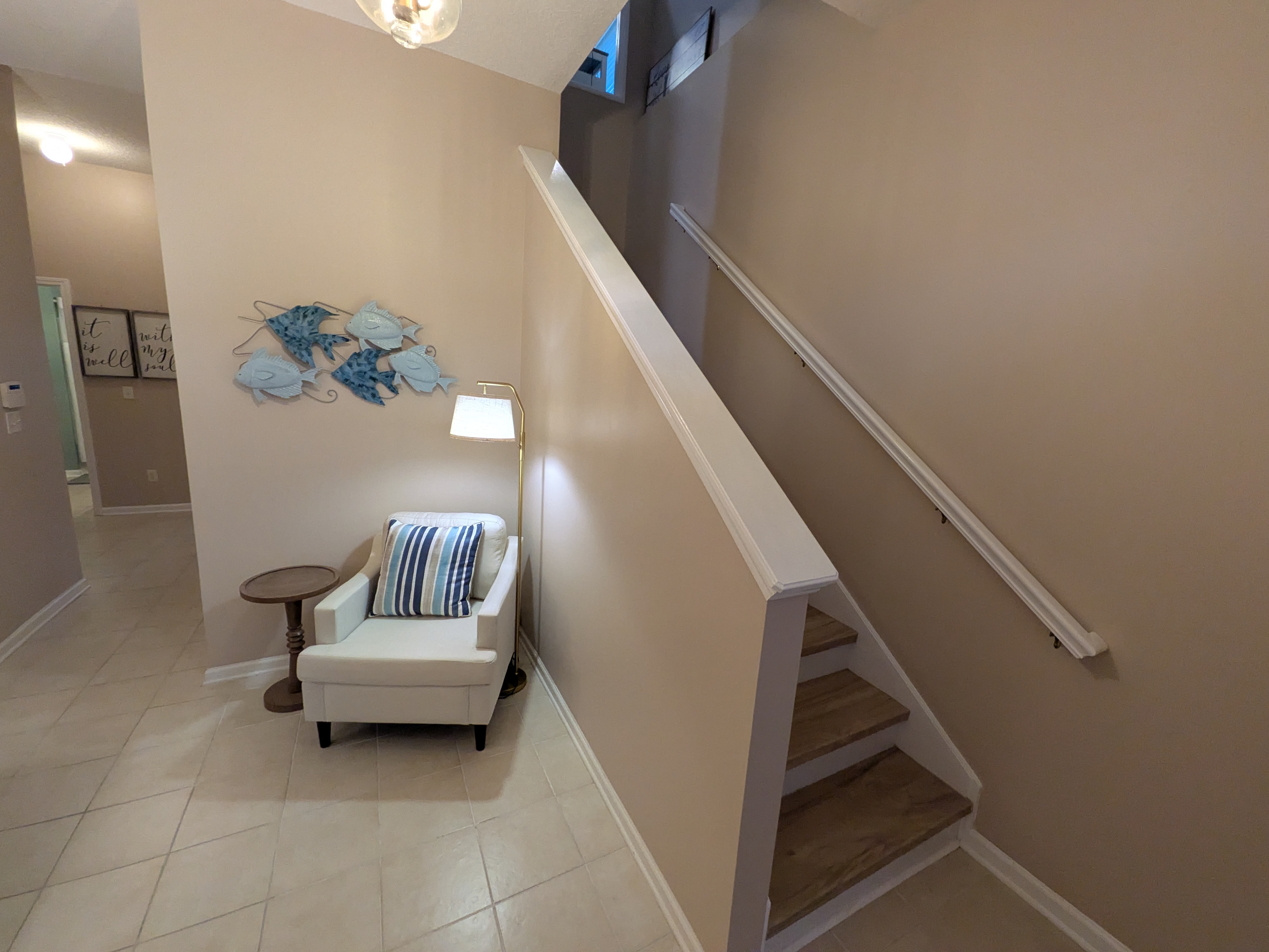 Bright entryway with cozy seating nook and airy staircase design
