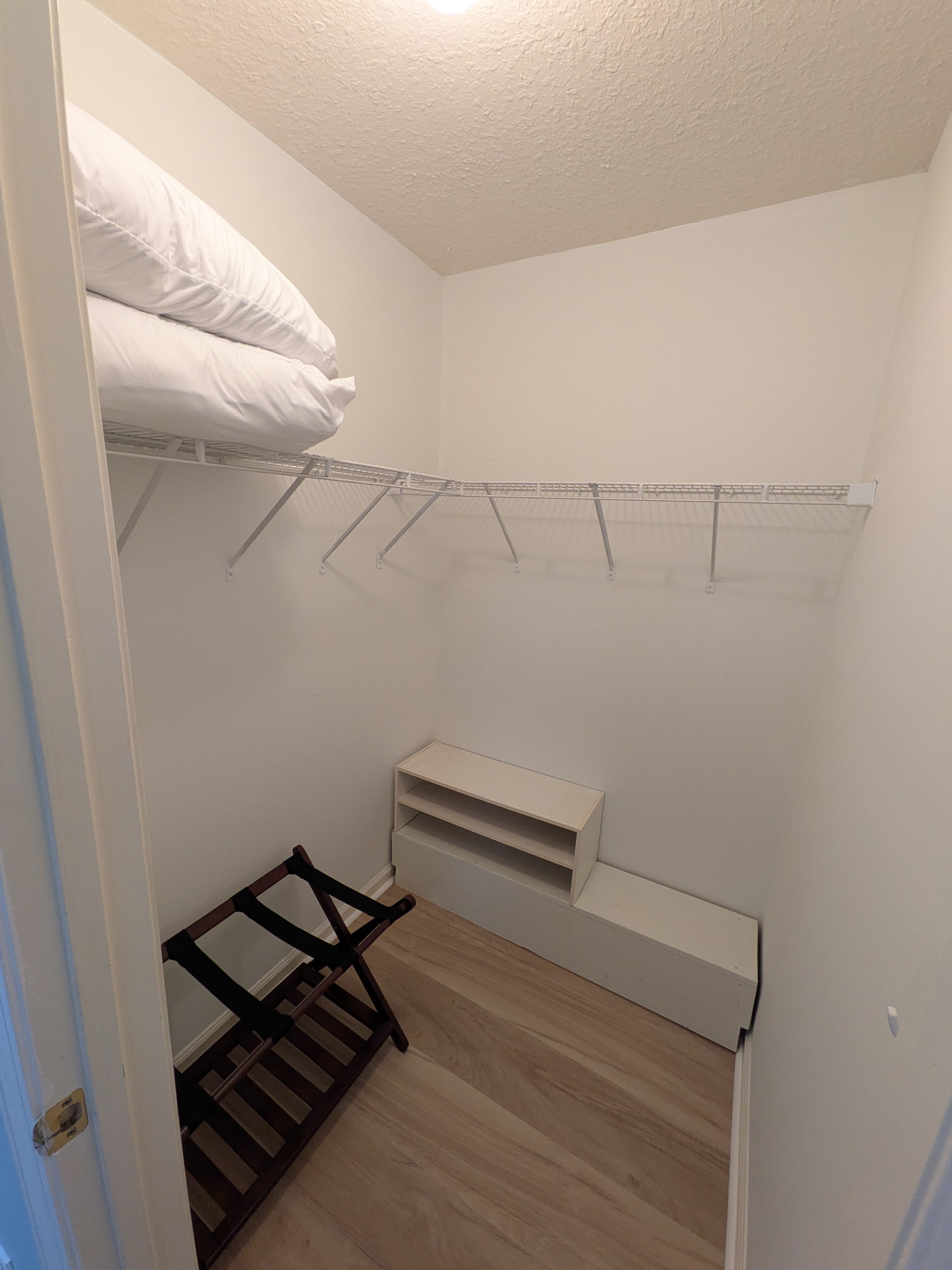 Spacious walk-in closet with luggage rack and plenty of storage