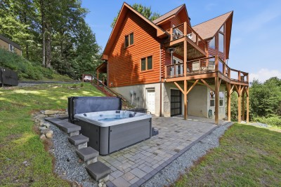 This mountain home's tiered decks and private hot tub patio open onto long, layered Blue Ridge views toward Grandfather Mountain, the kind of retreat where the scenery does the work, whether you're grilling at sunset or soaking beneath a starlit sky.