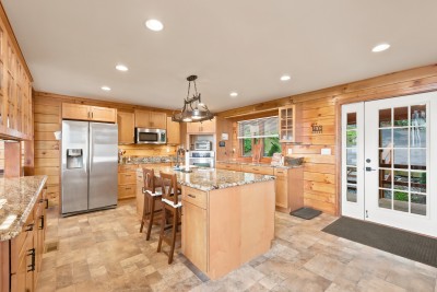 Gather around the granite island's prep sink and bar stools while dinner's on in the wall oven and cooktop. Glass-front cabinets and a wrought-iron chandelier warm up this wood-accented kitchen, which opens straight to the great room and dining area.