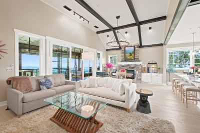 Cathedral ceilings and hand-hewn beams open the whole great room to the mountains. Top-floor living means light pours in from every angle, with the stone fireplace anchoring it all.