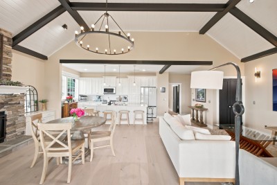 One easy, open floor plan: kitchen to dining to living, all under vaulted ceilings and all pointed at the view. Nobody gets stuck in another room.