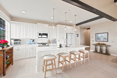 A fully renovated kitchen with all-new appliances, a gas range, and an island with seating for four - room enough to cook a real dinner and still talk to everyone.