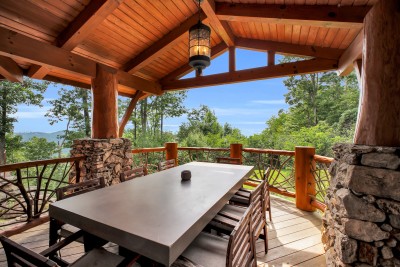 Gather the whole group around the long table under the timber pavilion, with layered Blue Ridge peaks rolling out beyond the rail.