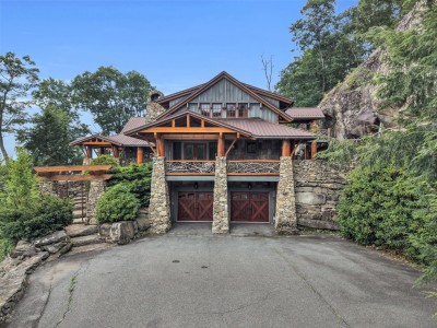 Head-on, the timber gables and stacked-stone garage line set the tone before you are even through the front door.