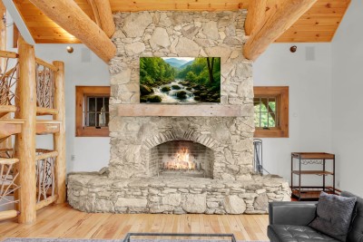 Nothing beats a crackling wood fire under a mantel of hand-stacked stone, framed by log beams reaching up to the peak of the roof.