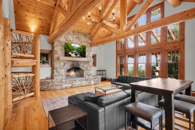 Curl up on the leather sectional in front of the stone fireplace, two stories of log trusses and picture windows rising overhead.