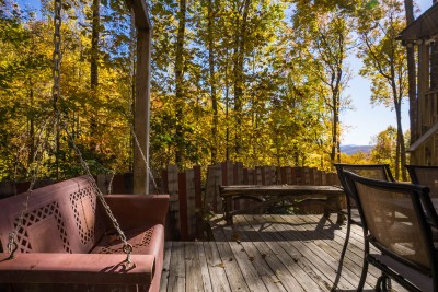 Private wooded deck retreat with a hanging porch swing, the perfect spot to sway the evening away, cozy tan curtains and sliding glass doors keep this quiet corner just steps from everything else.