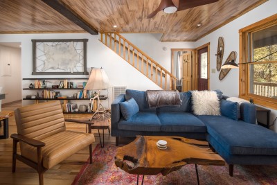 Cozy up in the great room beneath vaulted pine ceilings and exposed wood beams, where a stylish sectional invites the whole group to settle in by the stone fireplace.