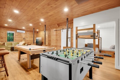 Cozy cabin game room with foosball, pool table, and built-in bunks