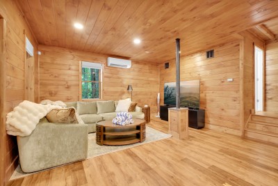 The lower-level den is where the movie gets watched. Big sectional, big TV, and its own mini-split so this floor sets its own temperature.