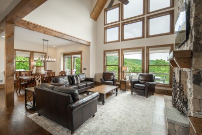 Kitchen, dining, and great room flow together under one cathedral ceiling, so nobody misses the conversation or the view.
