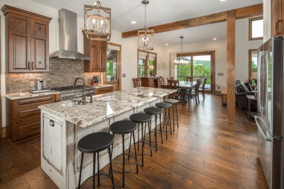 A long granite island seats five and the pro gas range makes Thanksgiving-scale cooking easy. The mountains are right there through the dining room glass.