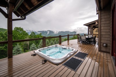 Sink into the in-deck hot tub with nothing in front of you but forested ridgelines and low mountain cloud. Best seat in the house, morning or midnight.