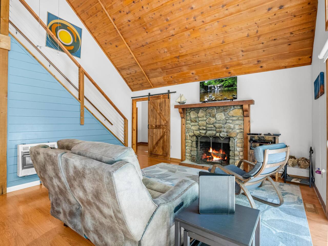 A powered reclining loveseat sits in front of a wood fireplace in a large room with cathedral ceilings. Great place to relax after exploring Catawba Falls, Lake Lure, Old Fort, Black Mountain, Asheville , the options are practically endless.