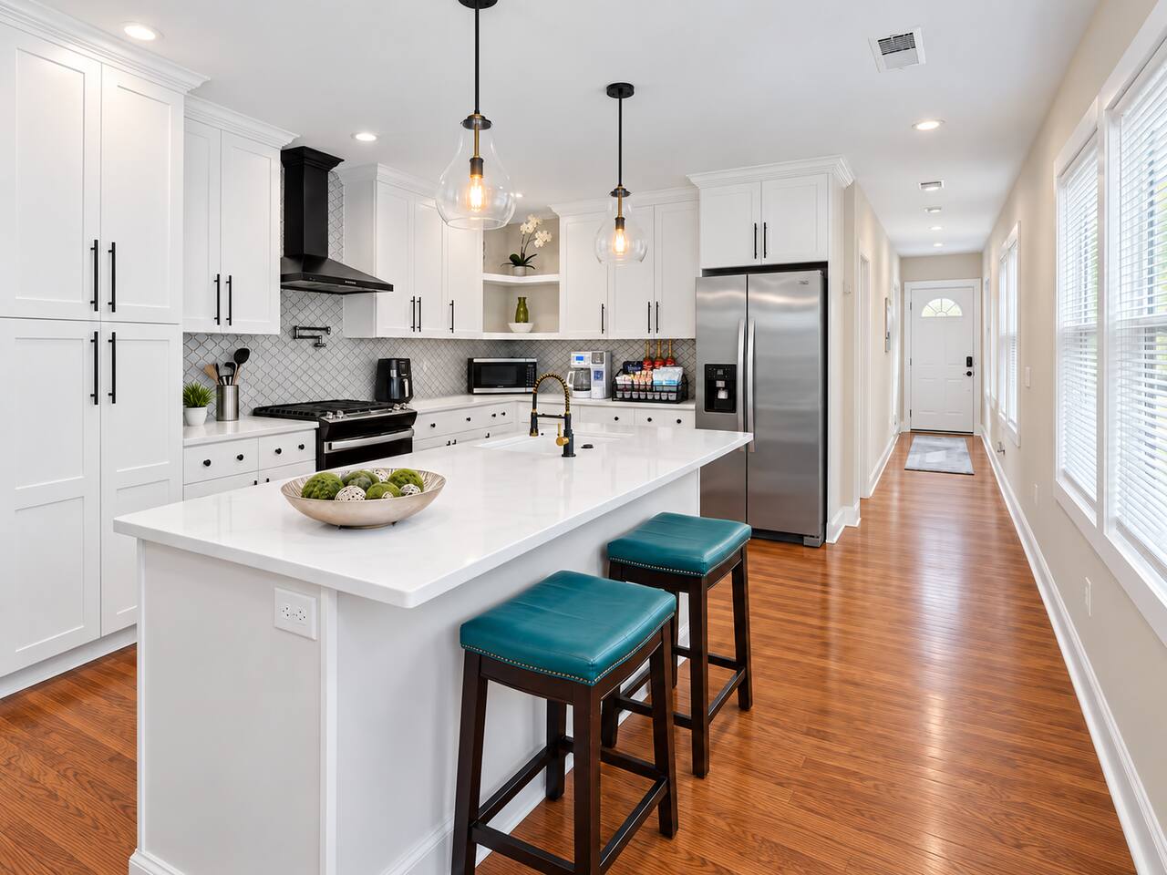 Cook and gather in the bright kitchen with quartz countertops, stainless steel appliances, a spacious island, and bar seating.