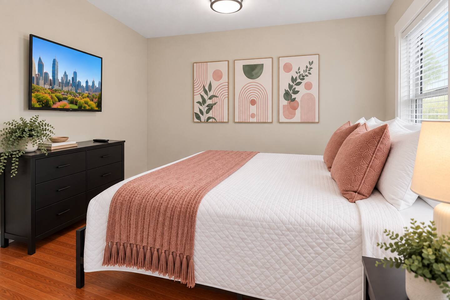 Soft pink accents, decorative artwork, and inviting bedding give this bedroom a cozy, home-away-from-home feel.