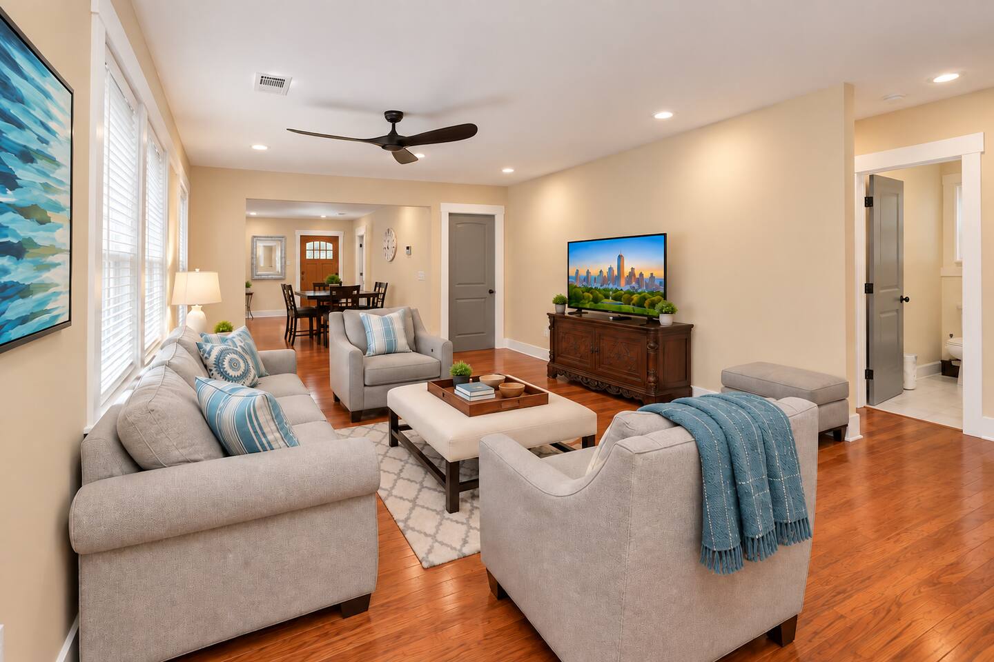 Relax in a comfortable open living space with plush seating, hardwood floors, a Smart TV, and plenty of natural light.
