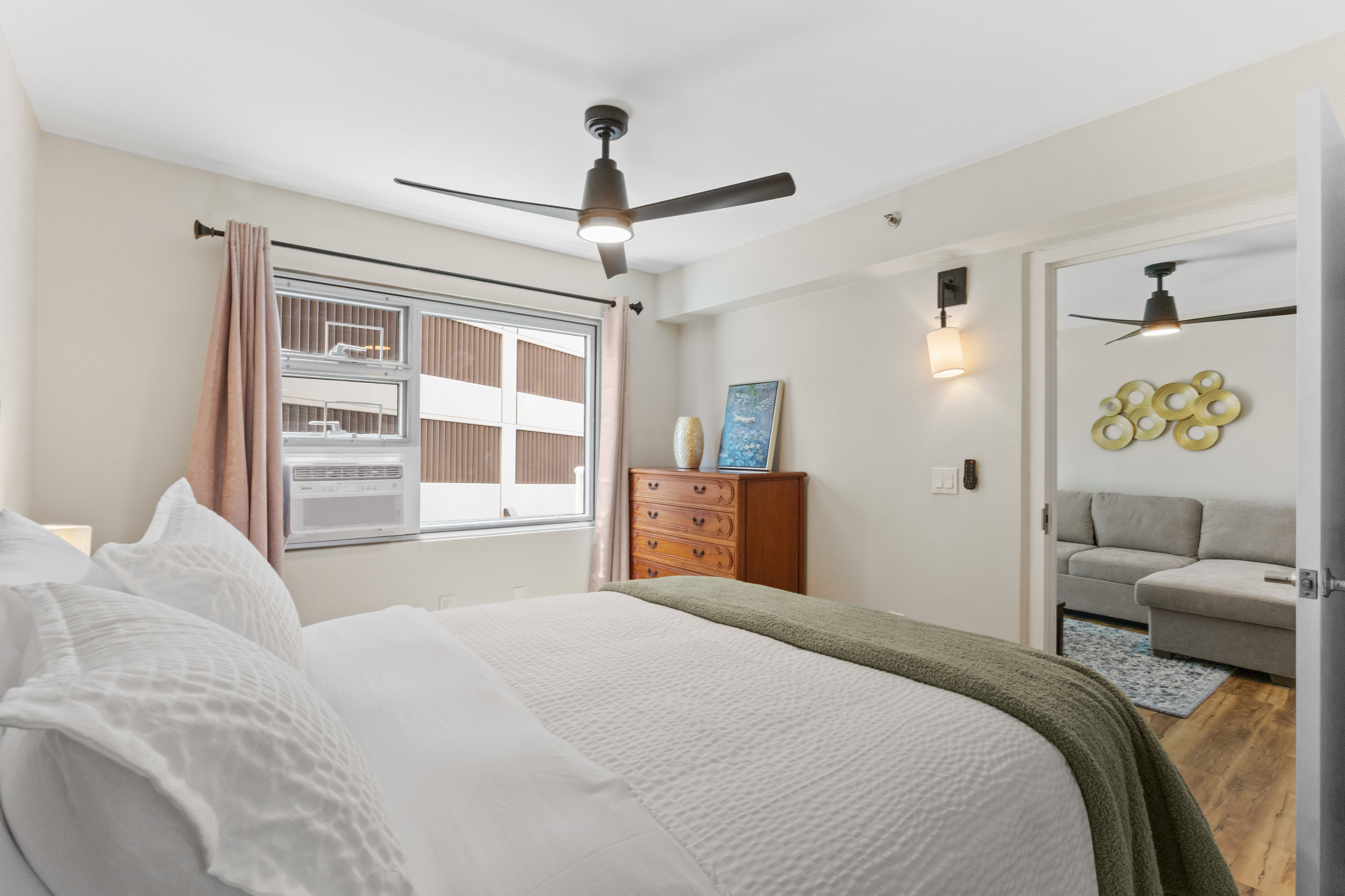 Bright, cozy bedroom with plush bedding and access to a stylish living area