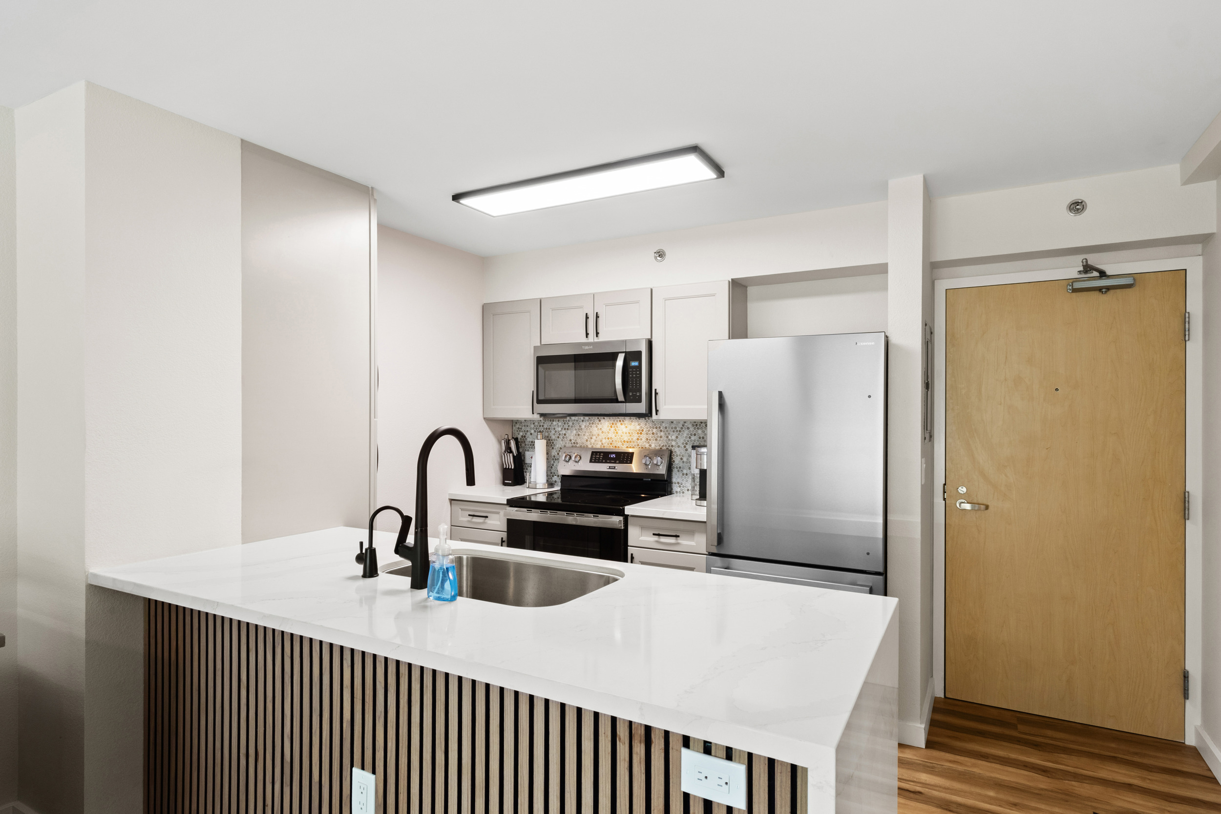 Modern kitchen with sleek island, stainless appliances, and bright finishes