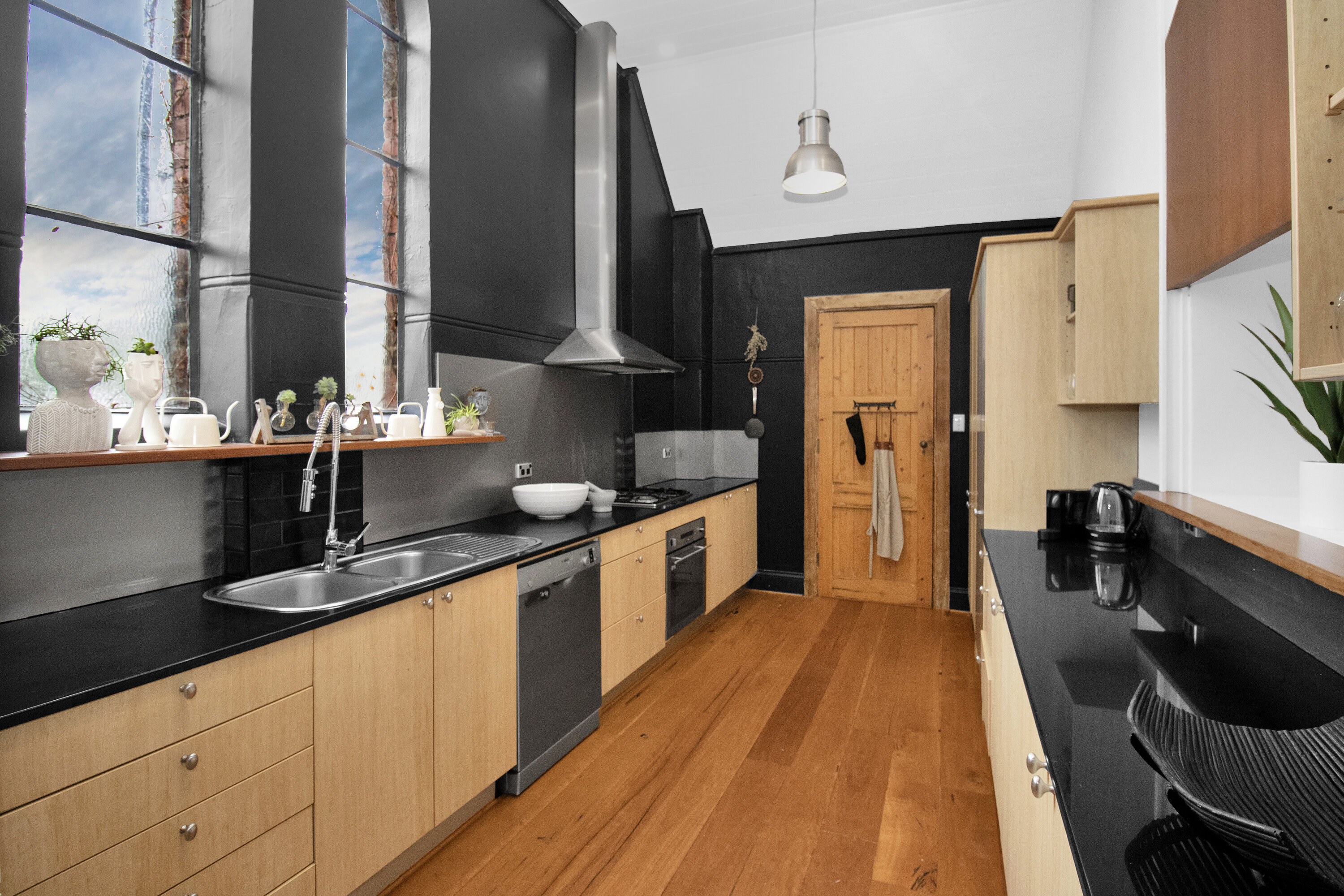 Bright designer kitchen with tall windows, bar seating, and sleek finishes
