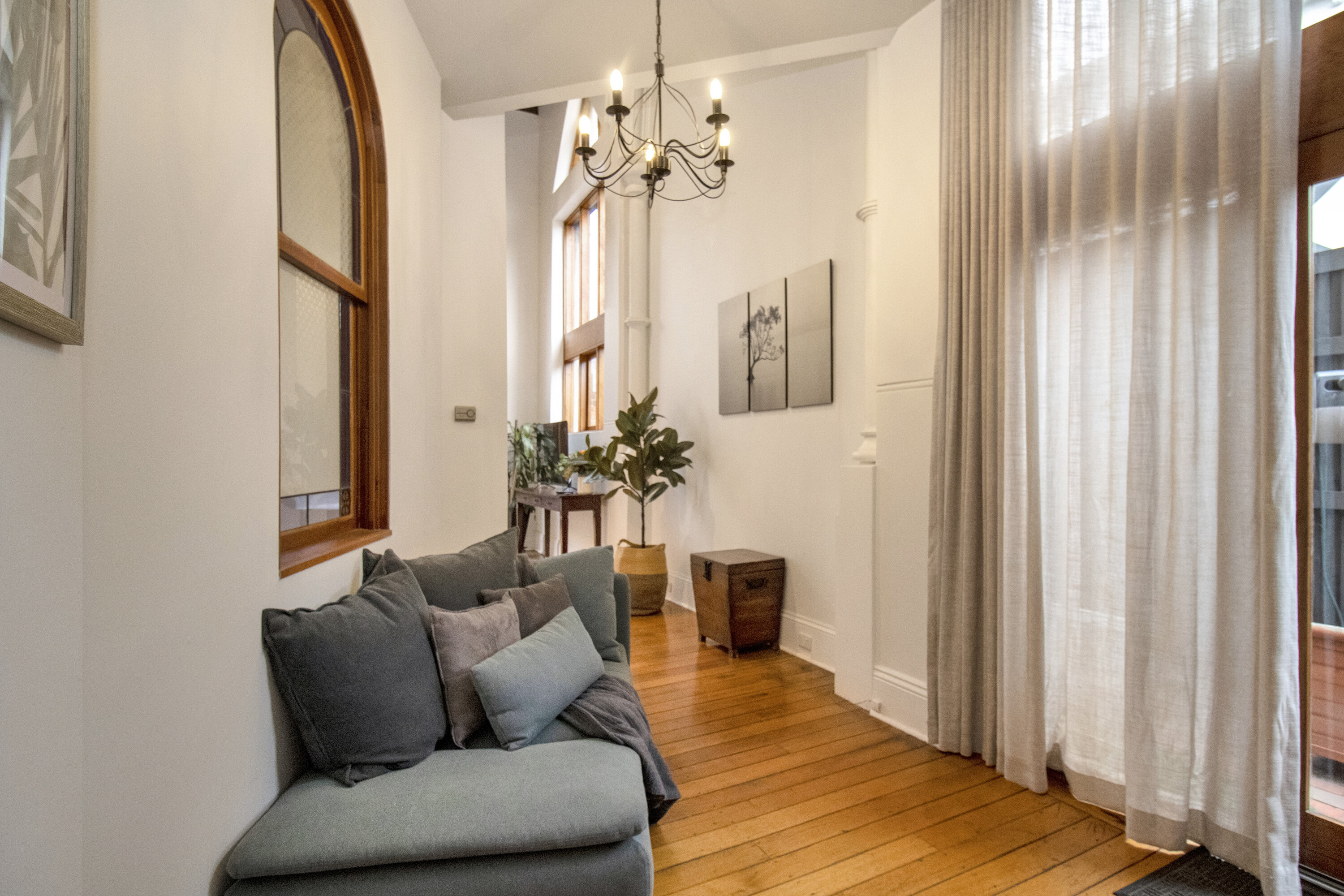 Bright lounge nook with arched windows, high ceilings, and elegant charm