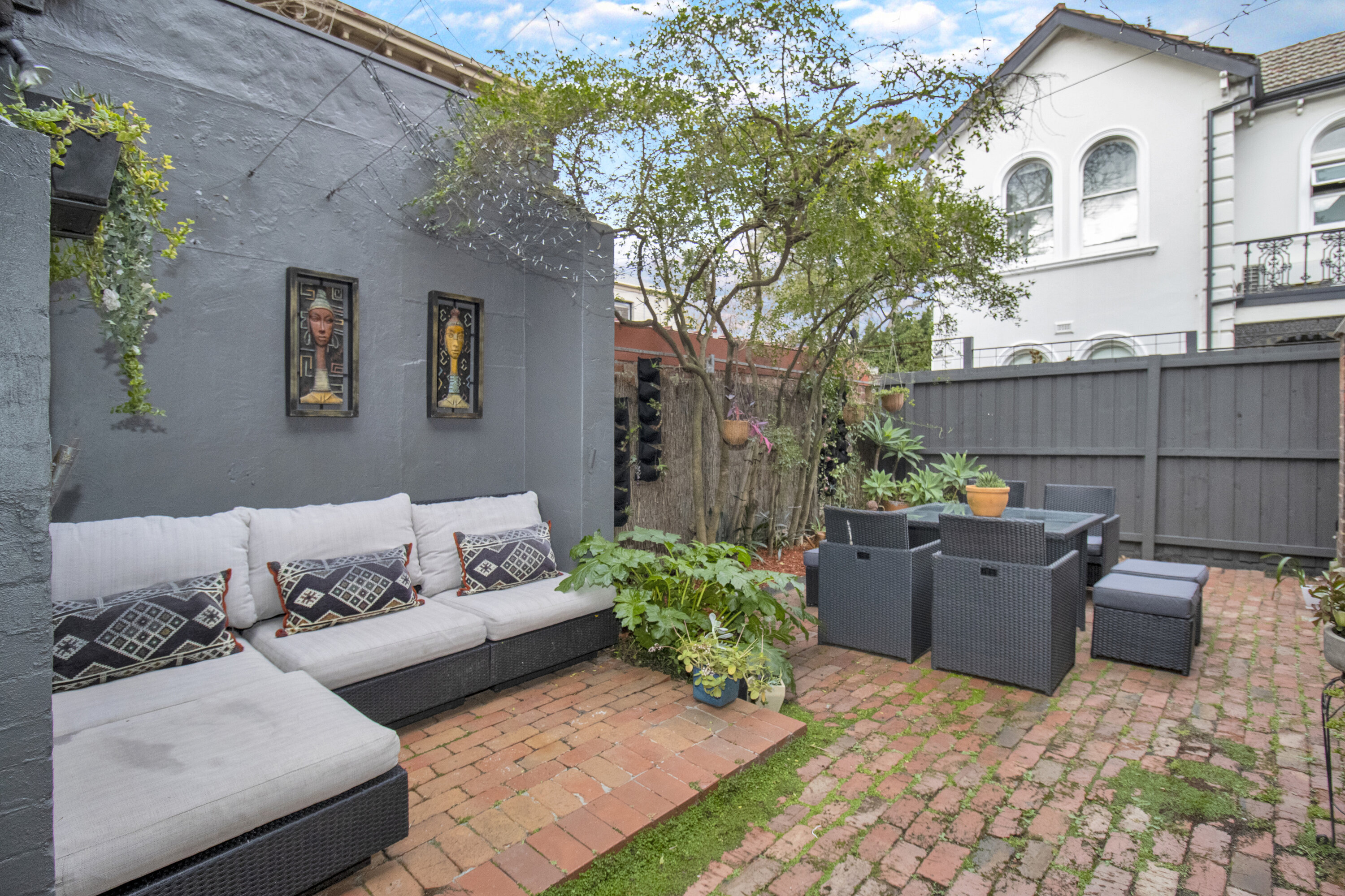 Private brick courtyard with lounge seating and outdoor dining