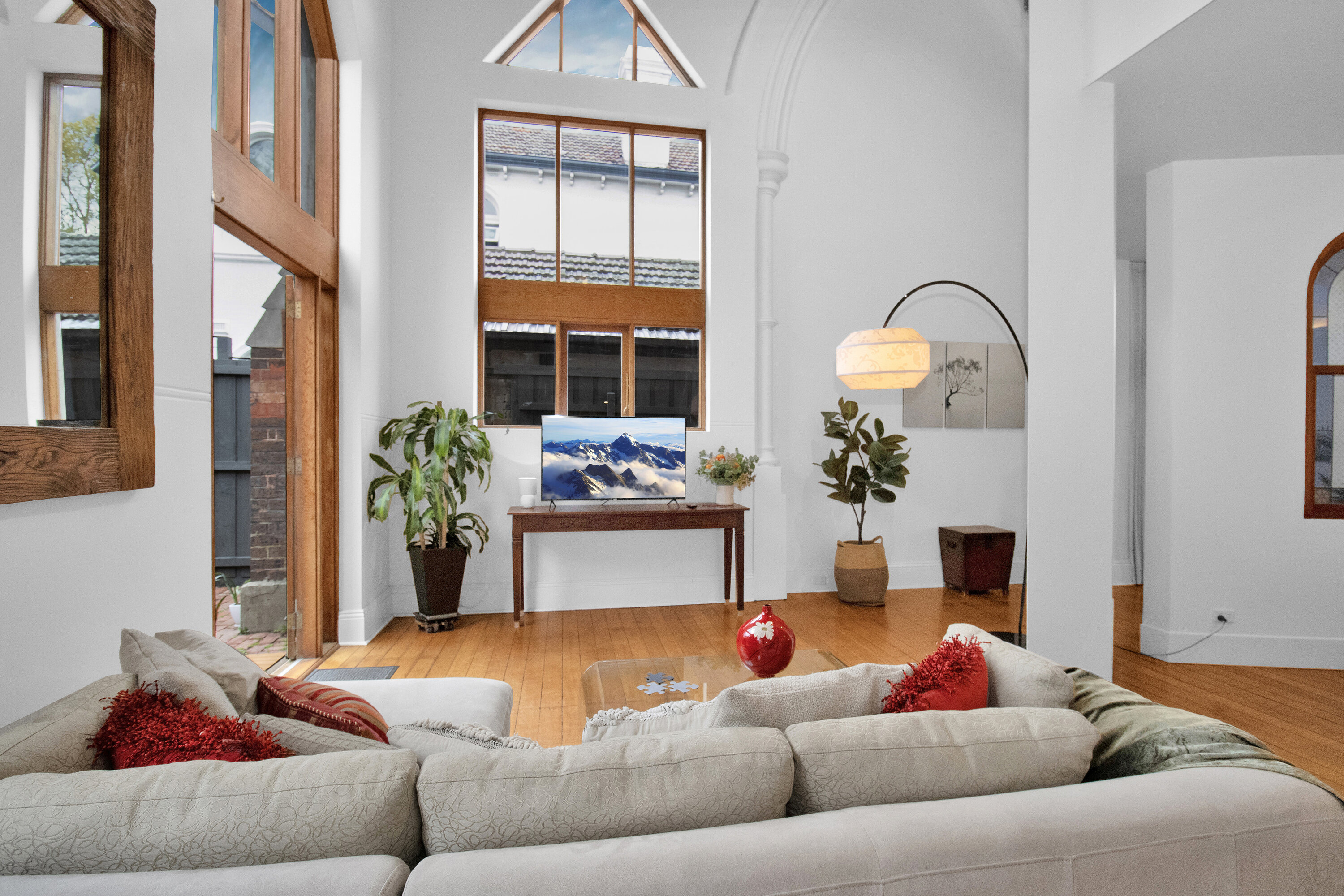 Bright living room with vaulted ceilings and dramatic floor-to-ceiling windows