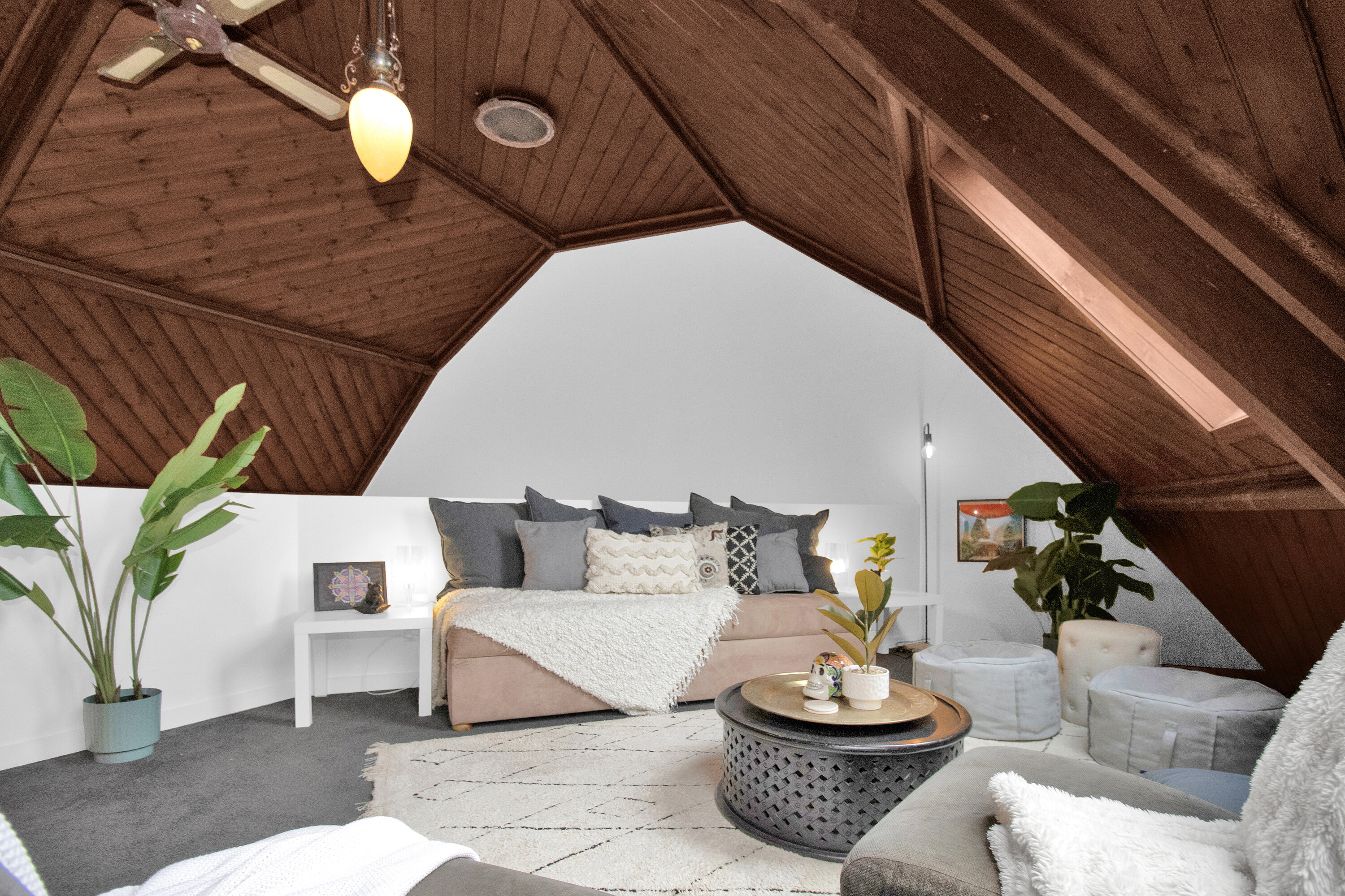 Cozy loft retreat with vaulted wood ceilings, skylight, and plush lounge seating