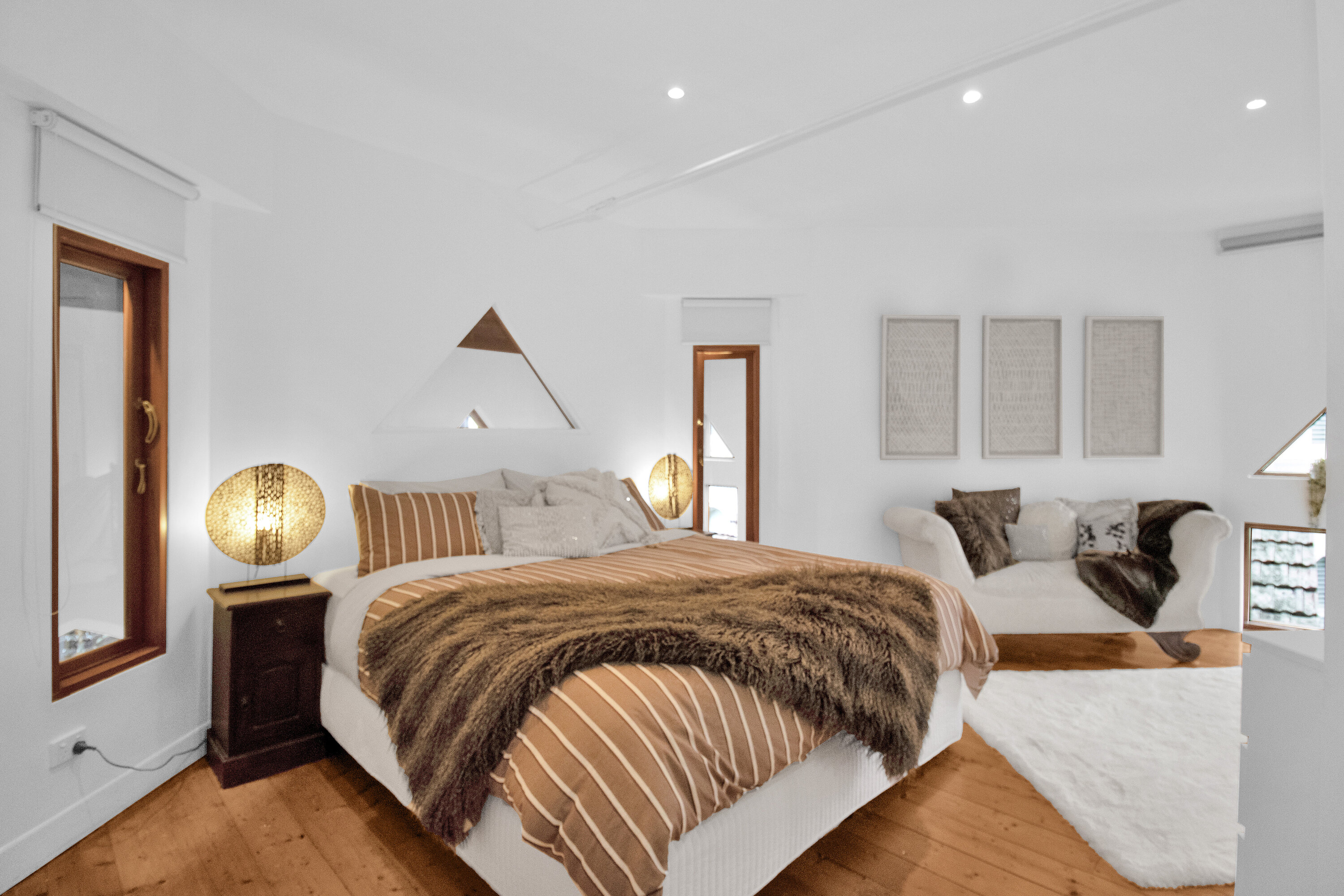 Bright, stylish bedroom with plush linens and a cozy seating nook