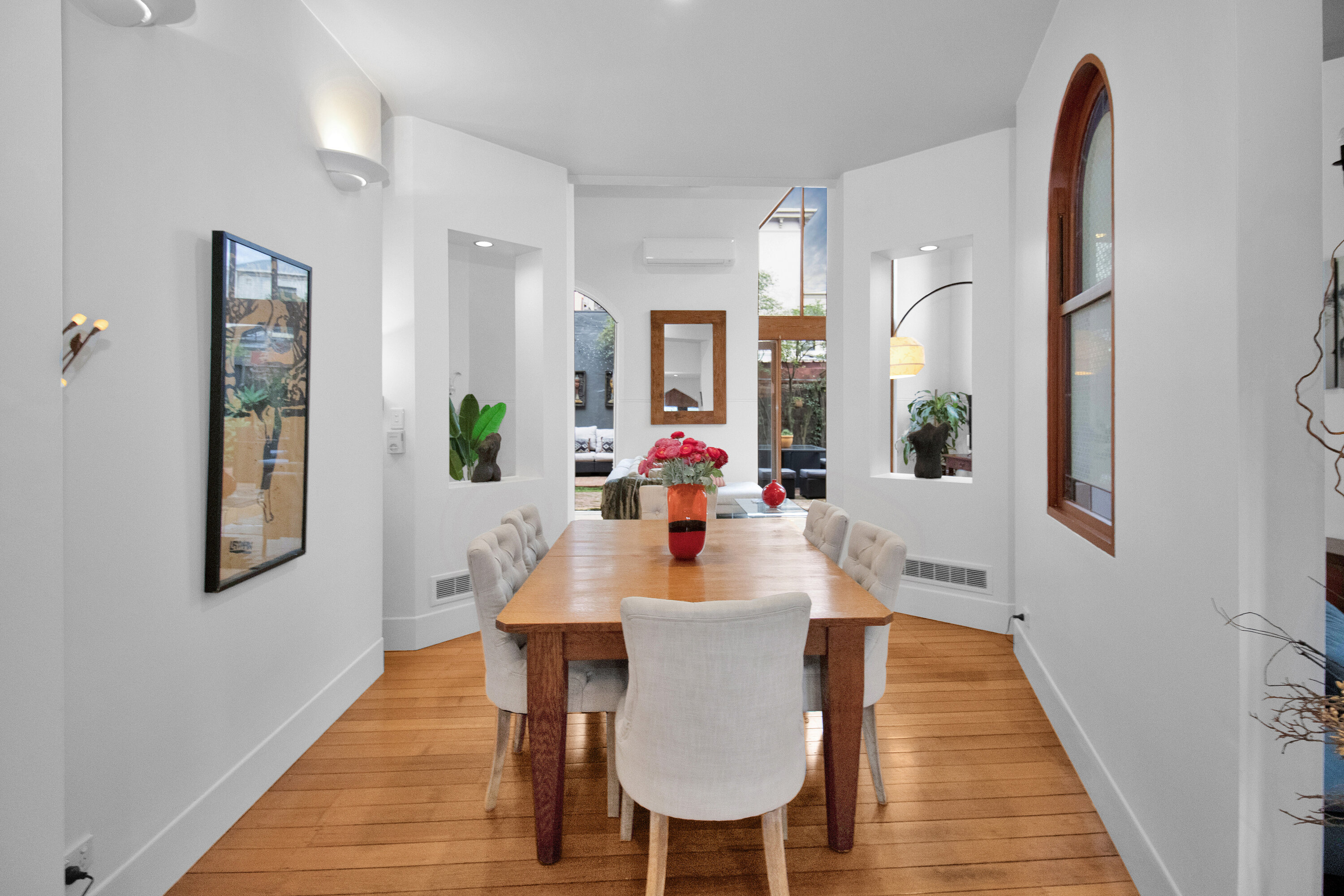 Bright modern dining room with warm wood floors and elegant architectural details