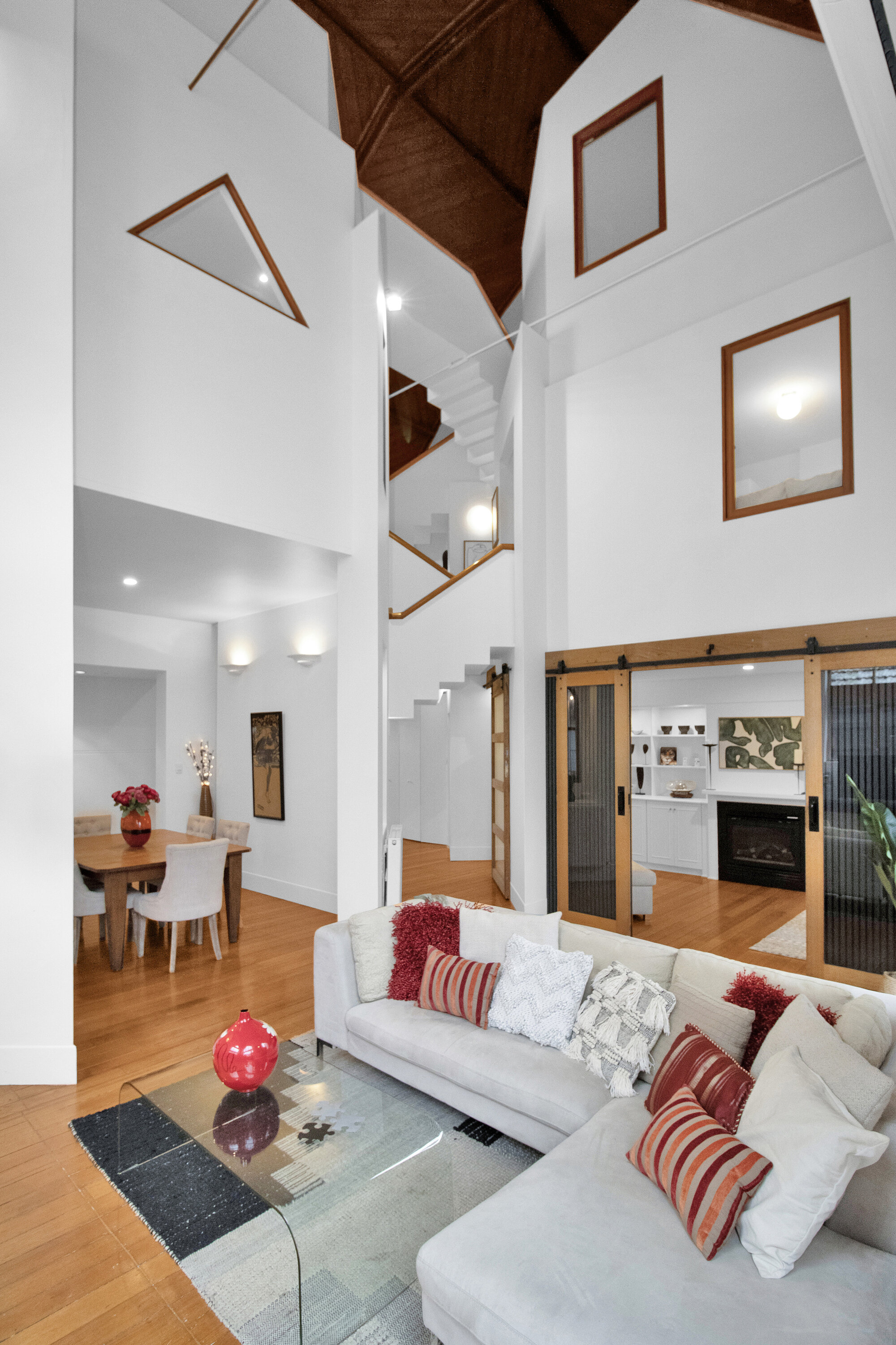 Bright open living space with vaulted ceilings, lofted design, and cozy fireplace