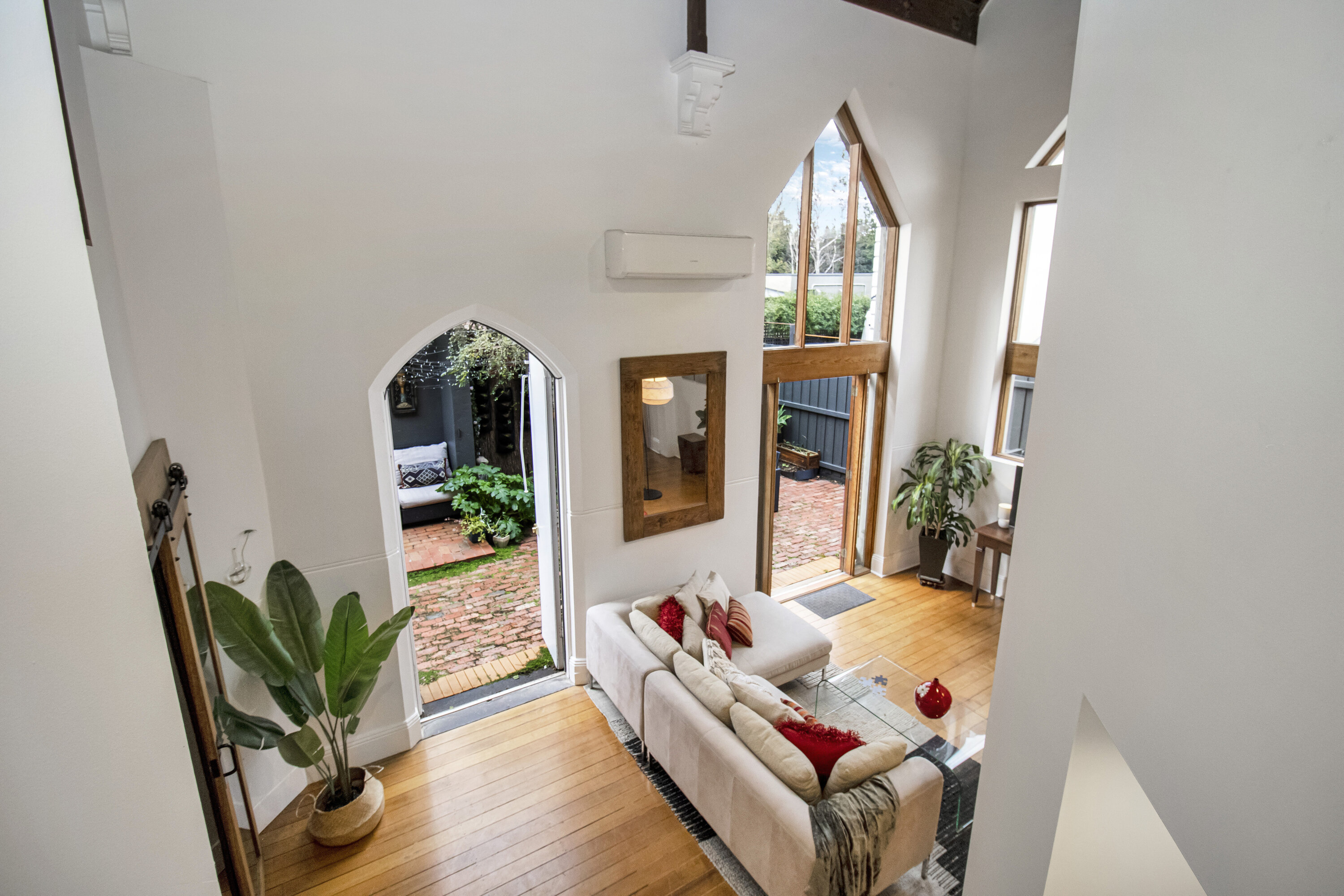 Airy vaulted living room with arched windows and courtyard access