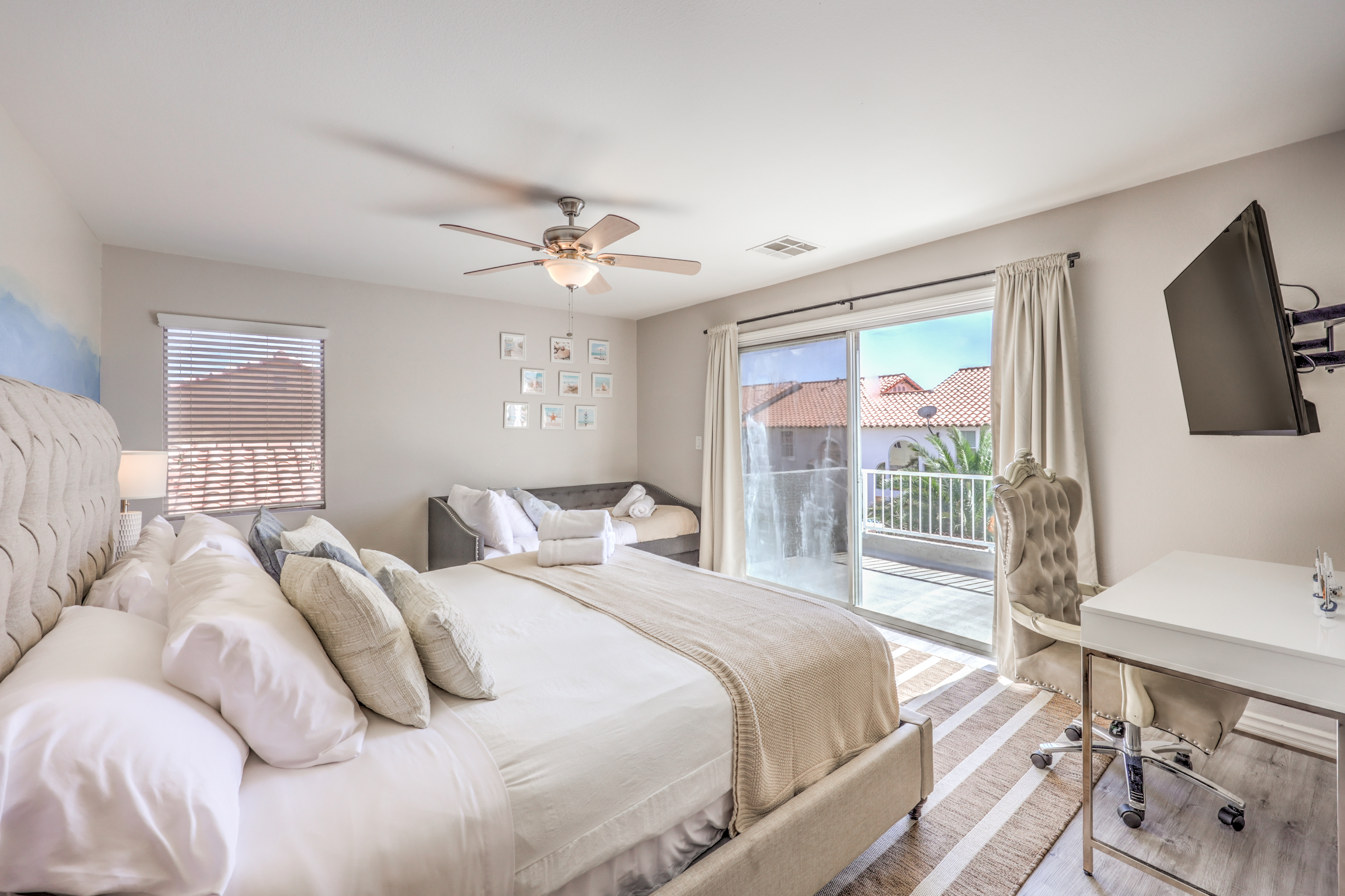 Bright bedroom with balcony access, desk space, and plush bedding