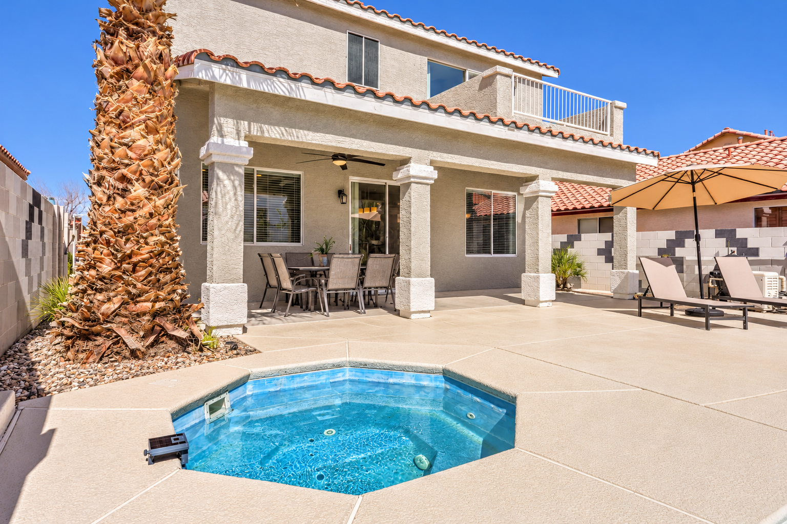Private backyard plunge spa with shaded patio dining and loungers