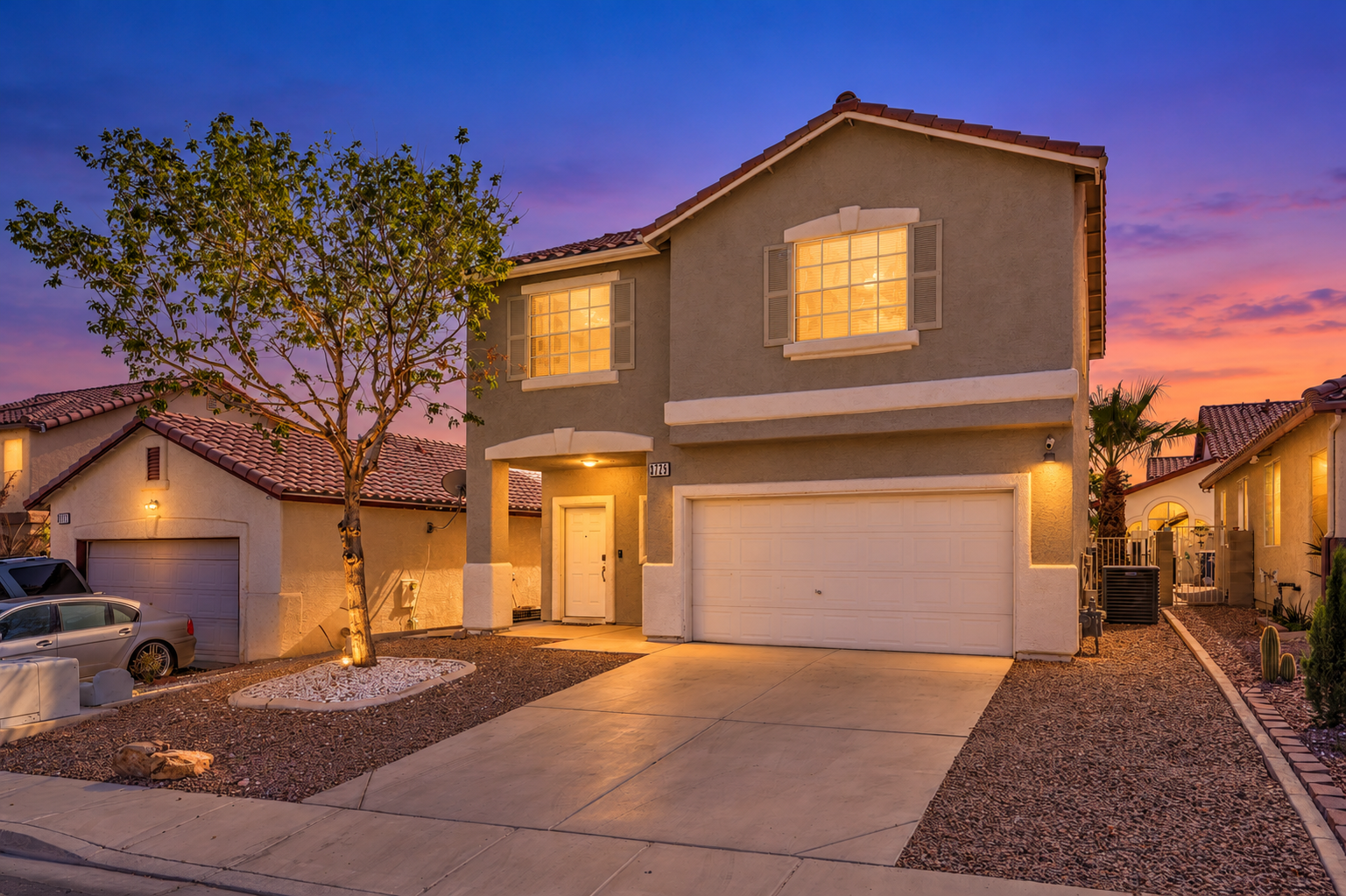 Inviting twilight exterior with warm lighting and spacious parking