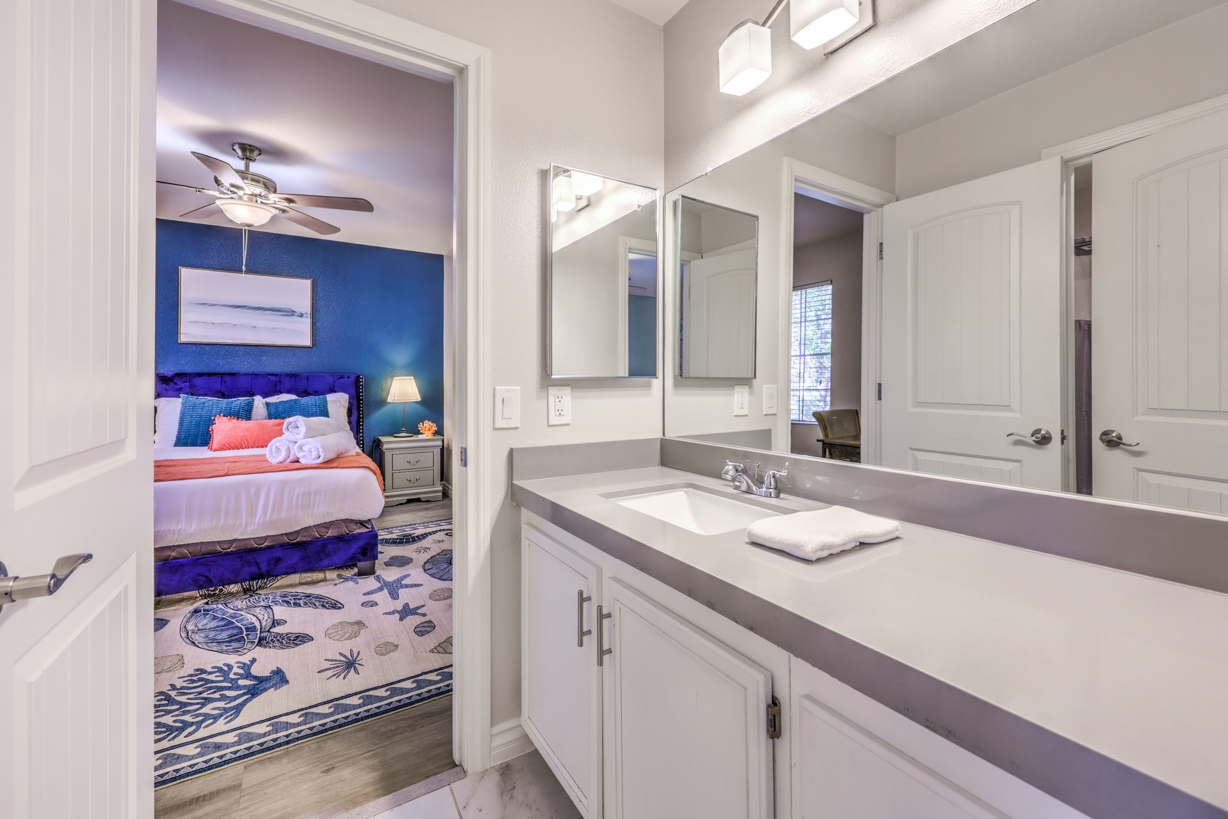 Bright modern bath with spacious vanity and cheerful coastal bedroom view
