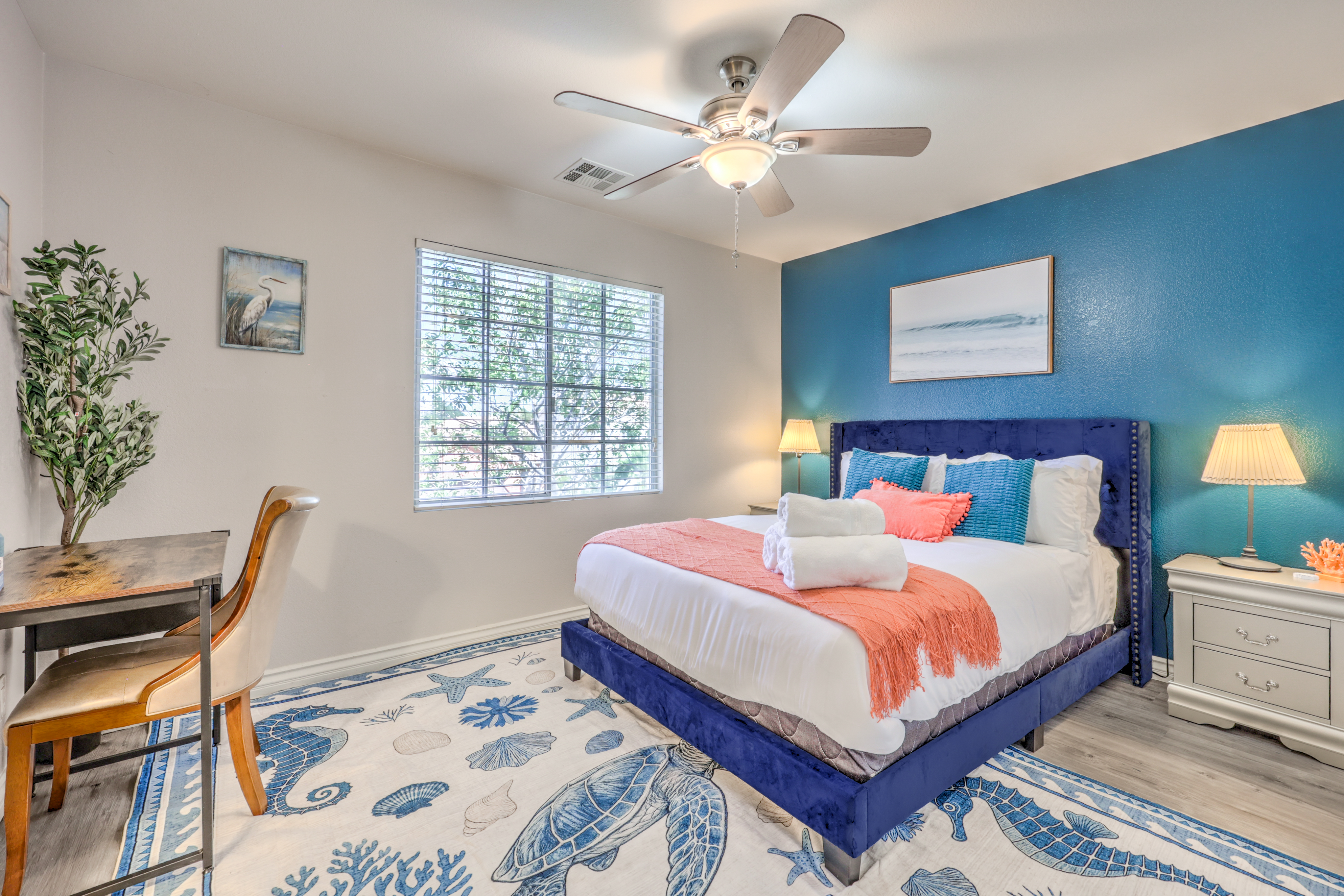 Bright coastal bedroom with plush king bed, workspace, and natural light