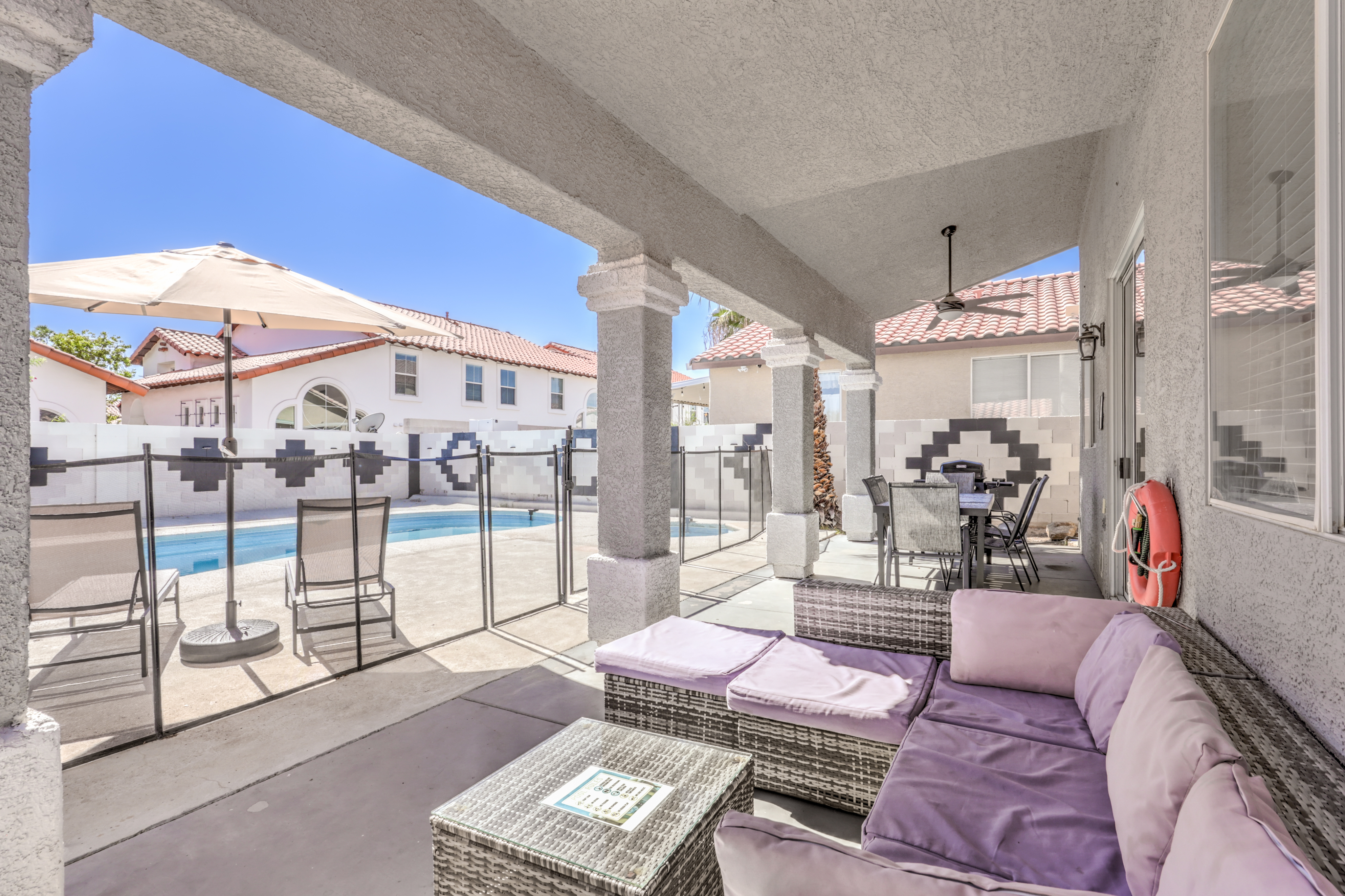 Covered patio lounge with fenced private pool and outdoor dining
