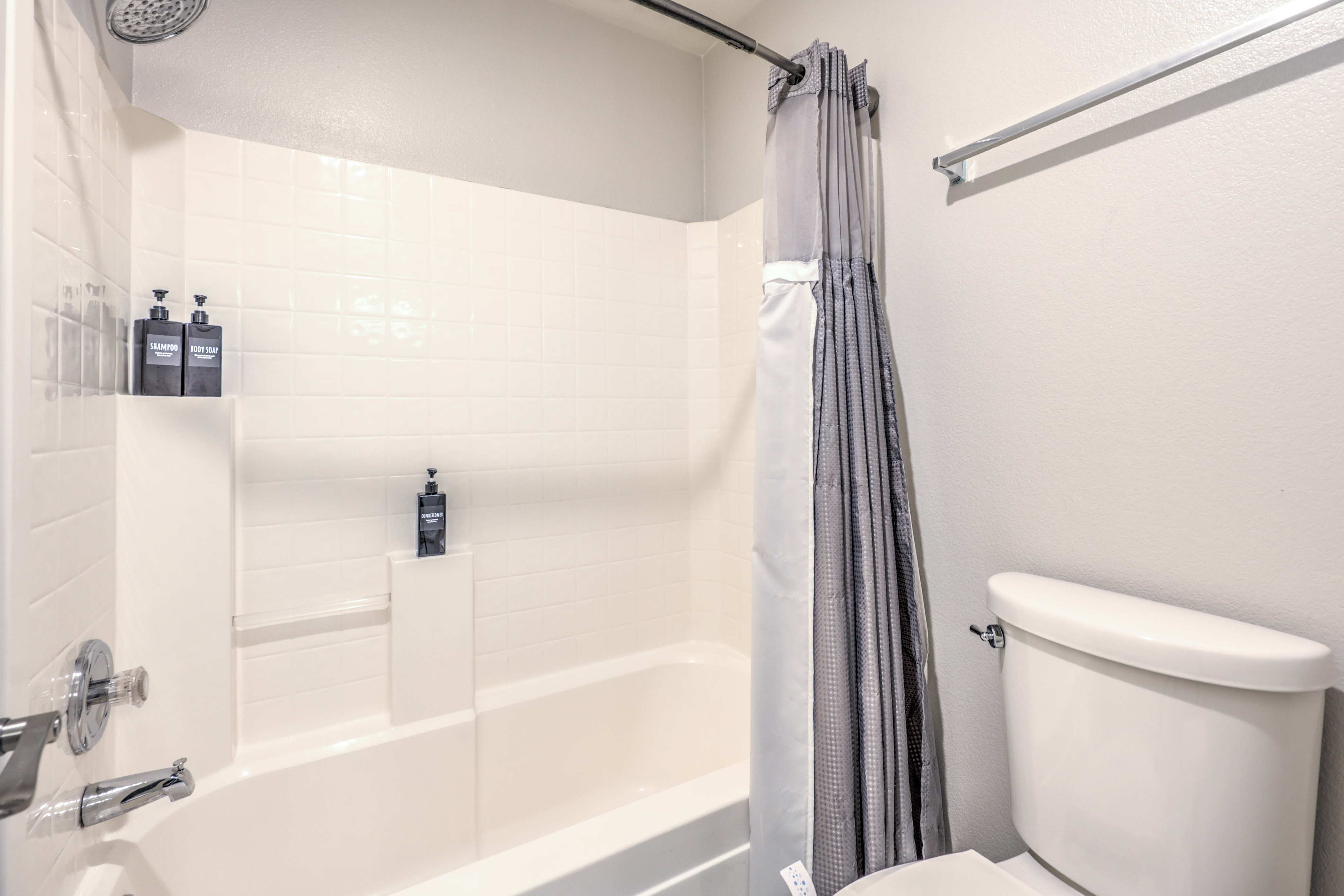 Bright, clean bathroom with tub-shower combo and rainfall showerhead